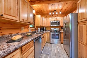 A kitchen with wooden cabinets, granite countertops, stainless steel appliances, and a wooden ceiling. - Memory Ridge Retreat, Sleeps 8, Walking Distance to Old Man's Cave (Logan)