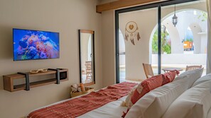 A bedroom with a TV, a bed, a window, and a view of the outside. - Paraíso Swim up Selva Ubicación Top (Tulum)