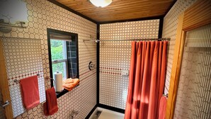 A bathroom with a white sink, toilet, and bathtub, featuring a hexagonal tile pattern on the walls and floor. - Mid Century Modern Casita, kitchenette, laundry, AC & pool in Uptown Phoenix (Phoenix)