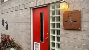 A building with a red door, a metal sign with 'JK Studios' on it, and a potted plant beside the entrance. - Mid Century Modern Casita, kitchenette, laundry, AC & pool in Uptown Phoenix (Phoenix)