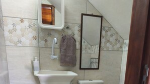 Een badkamer met een wastafel, toilet, spiegel en handdoekhouder.