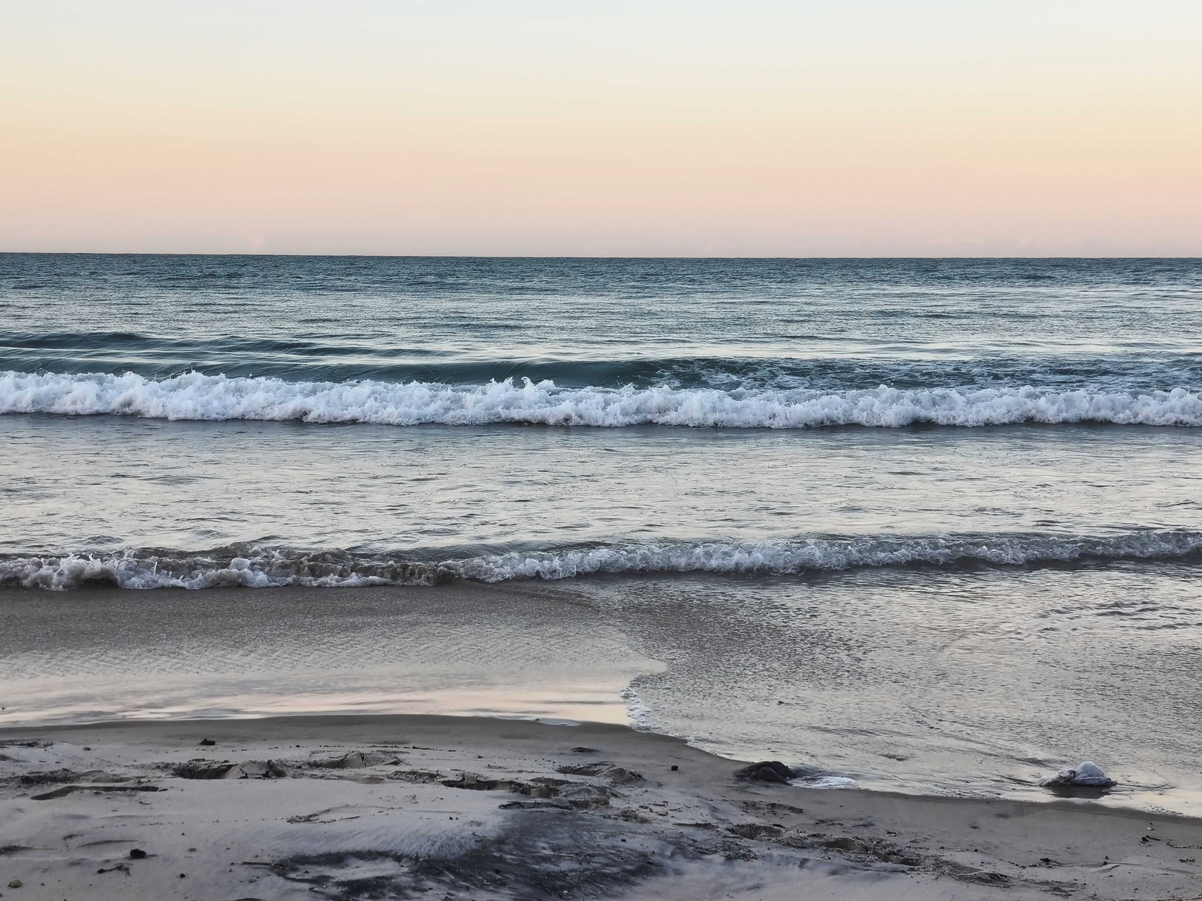 Uma praia com ondas e céu claro.