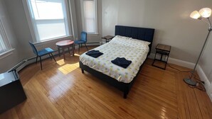 A bedroom with a bed, a chair, a desk, and a lamp. - Charming 2-bedroom apartment in charming Attleboro (Attleboro)