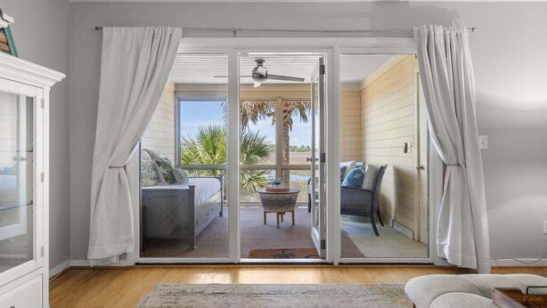 Habitación con puerta de vidrio corredera que da a un espacio exterior con una cama, una mesa y una silla.