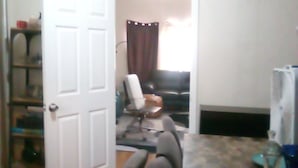 Une pièce comprenant une table à manger, des chaises, un téléviseur et une porte donnant sur une autre pièce.