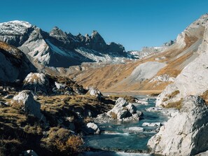 Un paysage montagneux traversé par une rivière qui serpente à travers une vallée rocheuse.