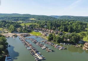An aerial view of a marina with boats docked, surrounded by residential buildings and greenery. - Relaxing 4-bedroom townhome on beautiful Cheat Lake in Morgantown, WV (Morgantown)
