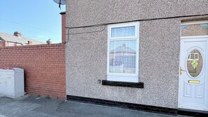 Ein zweistöckiges Wohnhaus mit Satellitenschüssel, Garagentor und kleinem Fenster.