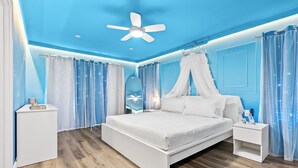 A bedroom with a bed, nightstands, a ceiling fan, and blue curtains. - 4BR Disney Area Home and Resort, Themed Rooms, Arcade Games, Gym and Pool. (Davenport)