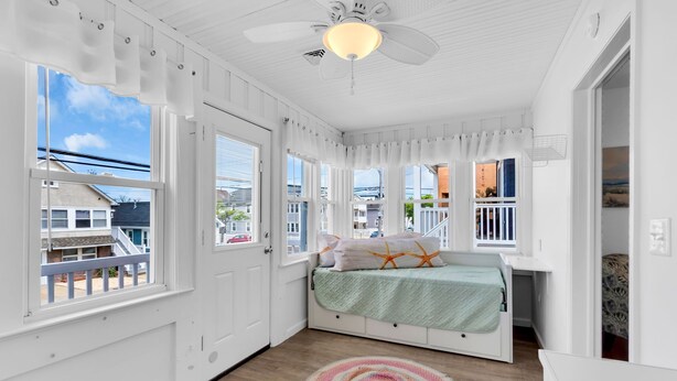 A room with a bed, a desk, and a view of the outside. - Game Room | 3 Blocks 2 Beach | Linens + Towels (Seaside Heights)