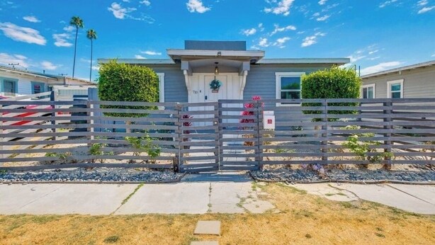 A modern two-story house with a gated entrance, a small porch, and a well-maintained lawn. - 0.5 Mile Walk To Sofi - Art Deco Beach Cottage - Entire Home (Inglewood)