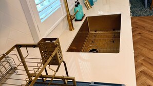 A kitchen with a white countertop, two sinks, a gold faucet, and a blue towel rack. - 0.5 Mile Walk To Sofi - Art Deco Beach Cottage - Entire Home (Inglewood)