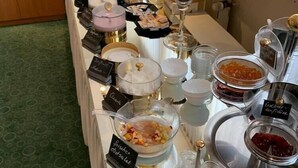 A buffet with various food items and condiments, including a candle centerpiece. - City Hotel Deutsches Haus (Hagen)