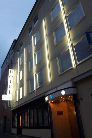 Ett hotell med flera våningar, ett stort och väl synligt hotellskylt, en entré i markplan och en hiss som är lätt att se.