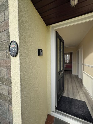 A house entrance with a number 5 mailbox, a doorbell, and a hallway leading to a bedroom. - 3-bedroom bungalow in enchanting Redruth perfect for relaxing getaways (Redruth)