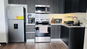 A modern kitchen with a stainless steel refrigerator, a microwave, an oven, and a toaster. - Modern loft, excellent location and total comfort (Ciudad de Guatemala)