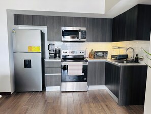 A modern kitchen with a stainless steel refrigerator, a microwave, an oven, and a toaster. - Modern loft, excellent location and total comfort (Ciudad de Guatemala)