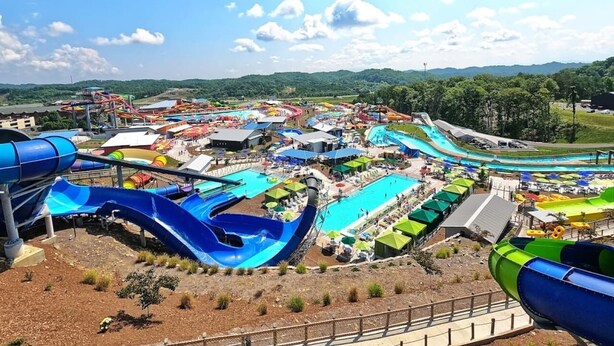 Ein Wasserpark mit mehreren Rutschen und Pools, umgeben von Hügeln.