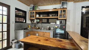 A kitchen with wooden cabinets, a granite countertop, a built-in oven, and a wooden dining table.