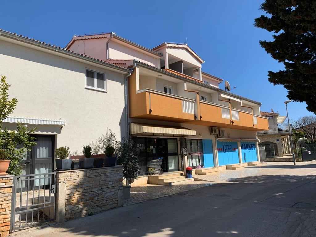 A two-story building with a ground-floor shop and a balcony.