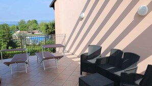 Una terraza con mobiliario exterior, piscina y vistas al paisaje.