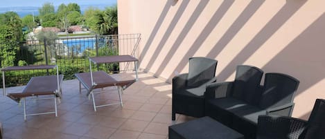 A terrace with outdoor seating, a pool, and a view of the landscape.
