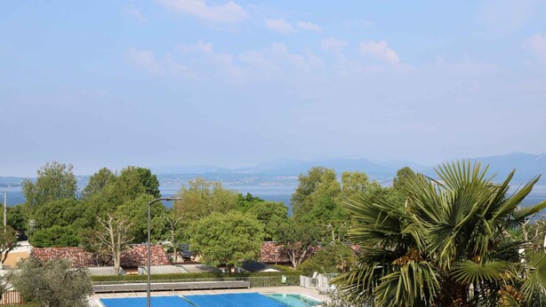 Zona de piscina con vistas al mar y a las montañas.
