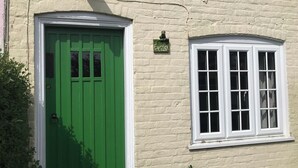 Un bâtiment avec une porte verte et une fenêtre blanche.