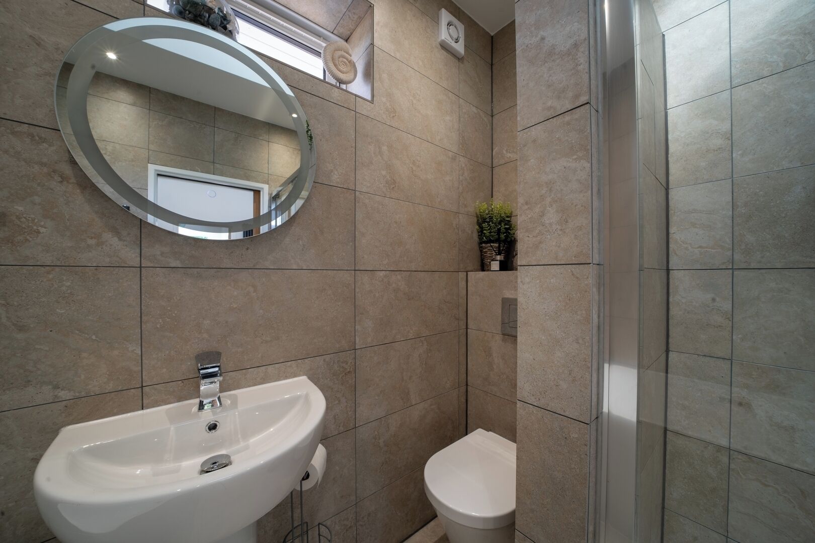 A bathroom with a sink, toilet, and a mirror.