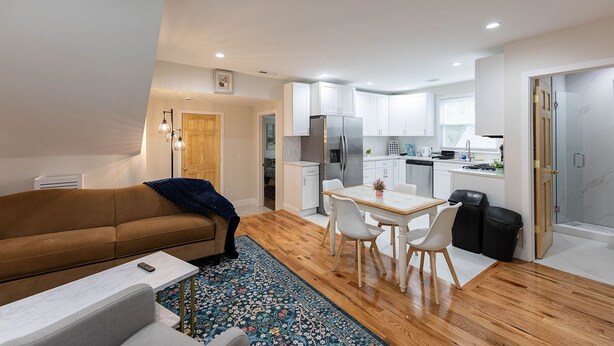 A modern apartment with a living room, dining area, kitchen, and a glass shower. - Comfortable 3BR/2BA Near Old Greenwich & Stamford (Stamford)