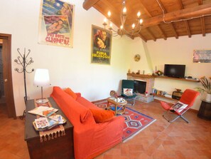 A living room with a sofa, a television, a fireplace, and a chandelier. - La Capannella by Interhome (Capannori)