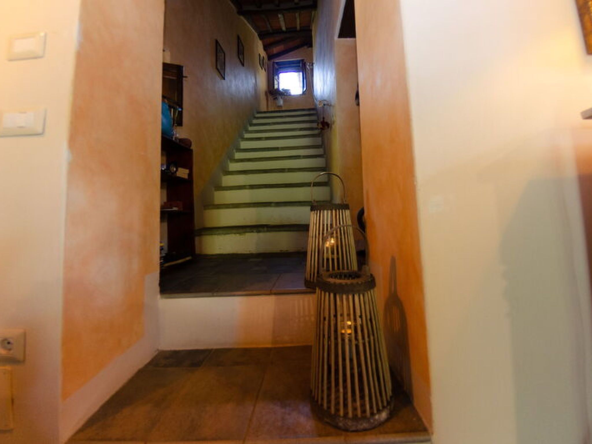 Una scala che porta a un pianerottolo con una lanterna.