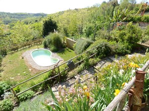 A garden with a heart-shaped pool, surrounded by greenery and flowers. - Al Colle Di Lari by Interhome (Lari)