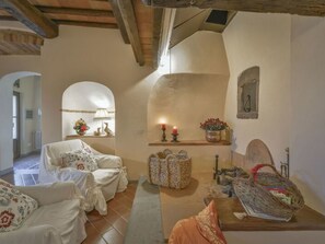 Ein gemütliches Zimmer mit Kamin, einem Bett, einem kleinen Tisch mit Kerzen und einem Korb.