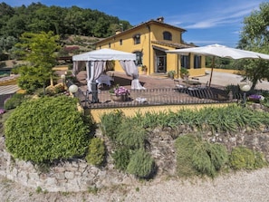 A yellow villa with a patio, outdoor seating, and a stone wall. - Villa Sandra Ortensia by Interhome (Casalguidi)