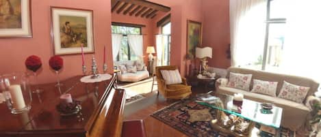 Una sala acogedora con un piano, un sofá, una silla y una mesita de centro.
