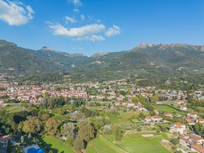 A town nestled in a valley with a mountain backdrop, featuring a mix of residential buildings and green spaces. - Casale 180 by Interhome (Camaiore)