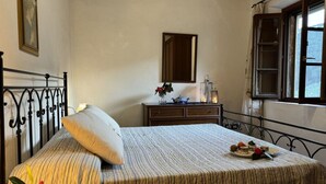 A bedroom with a bed, a dresser, a mirror, and a window. - Podere Di Mero Casolare by Interhome (Buti)