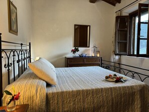 A bedroom with a bed, a dresser, a mirror, and a window. - Podere Di Mero Casolare by Interhome (Buti)