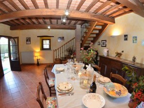 Un coin repas avec une table dressée pour quatre personnes, un escalier et un radiateur.