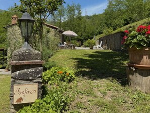 A stone sign with a bird and the word 'Anfora' in a garden setting. - Anfora!! by Interhome (Pescia)