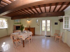 A dining area with a wooden ceiling, a table set for four, and a fireplace. - Anfora!! by Interhome (Pescia)