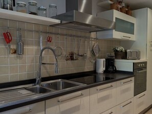 A modern kitchen with stainless steel appliances, a double sink, and a coffee maker. - Anfora!! by Interhome (Pescia)