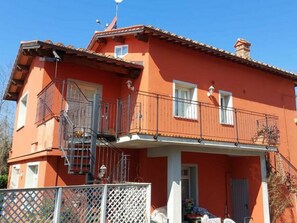 A two-story building with a red facade, balconies, and a visible staircase. - Borgo Di Zacco by Interhome (La Sassa)