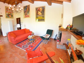 A living room with a sofa, armchair, and a fireplace. - La Capannella Del Cinema by Interhome (Capannori)