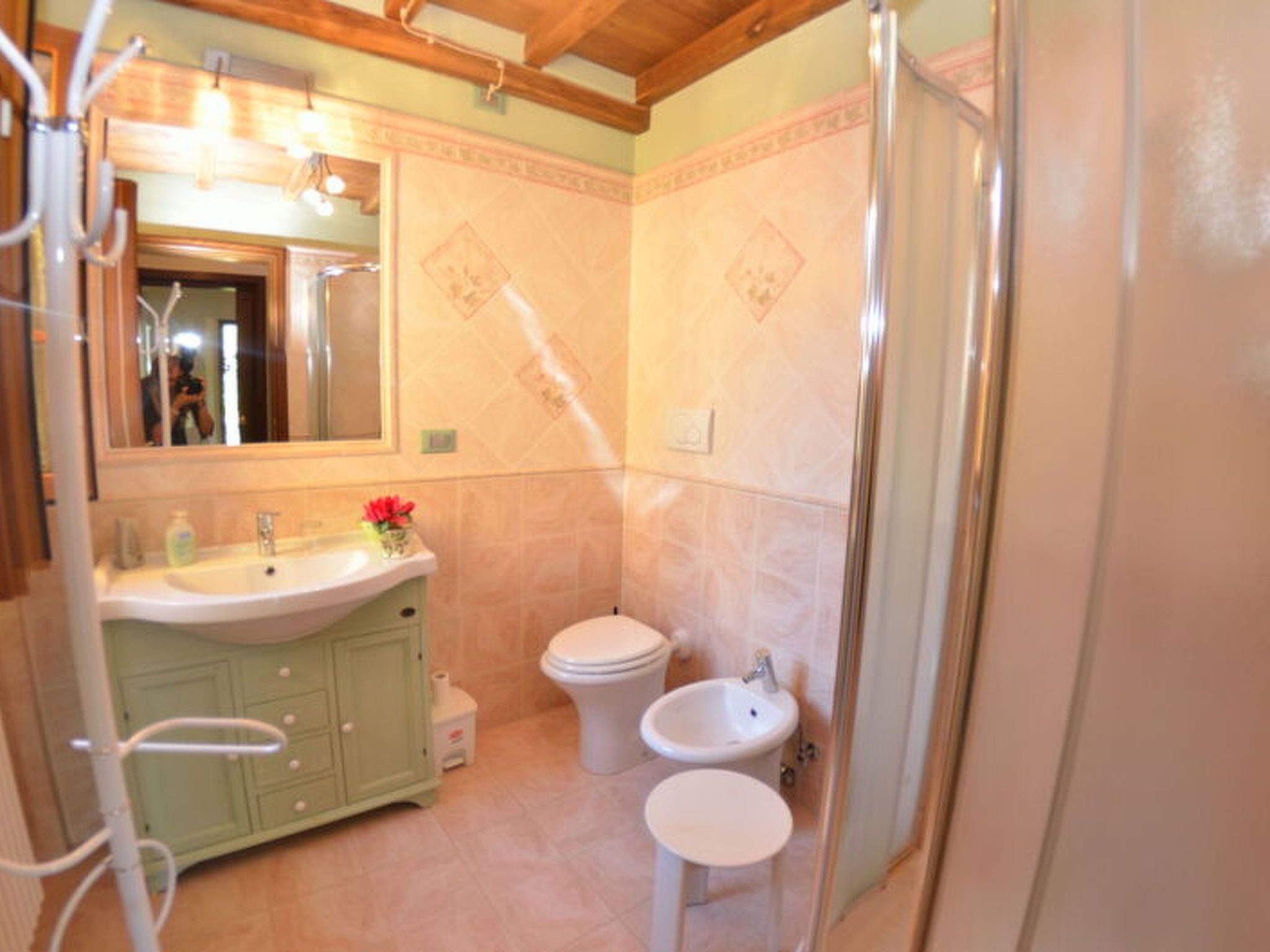Ein Badezimmer mit Waschbecken, Toilette, Bidet und Duschbereich.