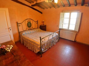 A bedroom with a bed, a radiator, a window, and a door. - Podere Aida Proprietà by Interhome (Capannori)