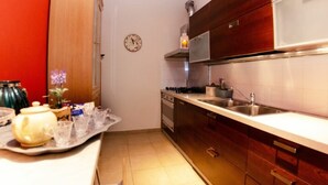 A compact kitchen with wooden cabinets, a stainless steel sink, and a clock on the wall. - Casale Al Sasso by Interhome (Capannori)
