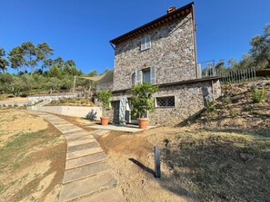 A stone house with a paved driveway and potted plants. - Casale Al Sasso by Interhome (Capannori)