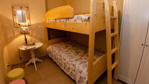 A bunk bed room with a small table and stool, a cabinet, and a wall-mounted lamp. - Casale Al Sasso by Interhome (Capannori)